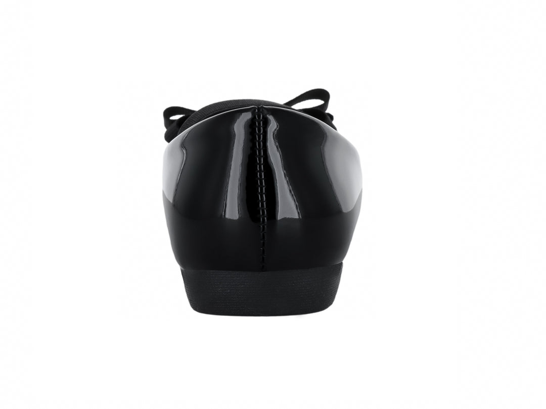 Zapato plano negro brillante con moño decorativo y correa superior.