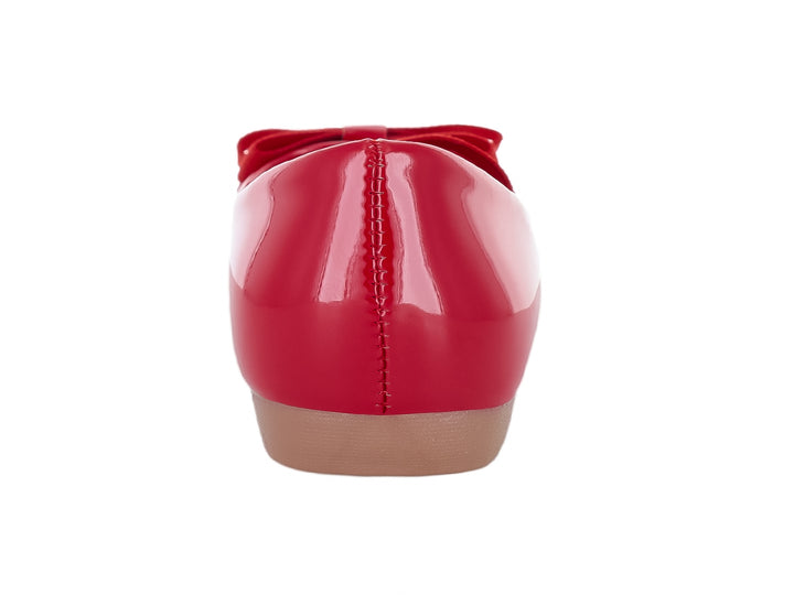 Zapato plano rojo brillante para niña con un moño decorativo en la parte superior y suela beige.