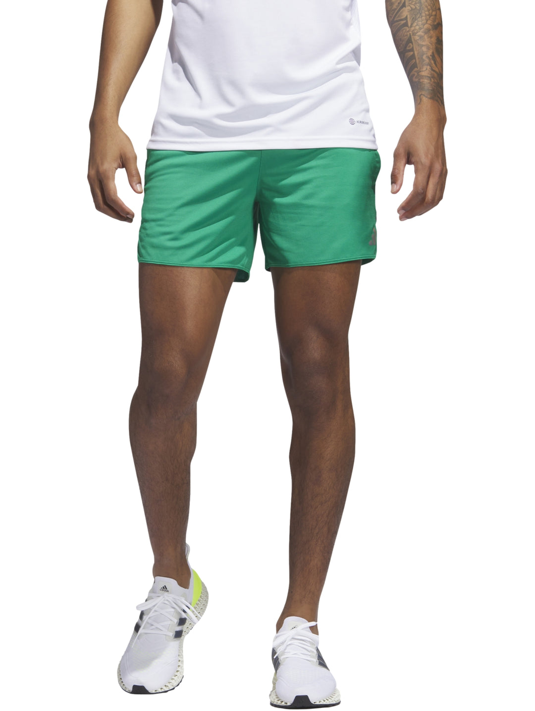 Hombre vistiendo pantalón corto deportivo color verde de la marca Adidas