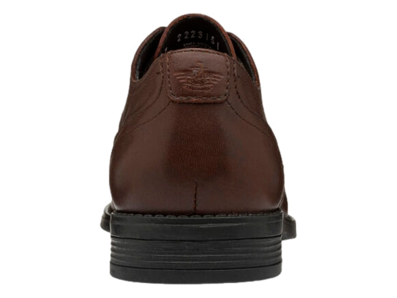 Zapato Oxford de cuero color caoba con detalles perforados y suela negra.