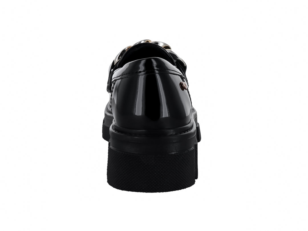 Zapato mocasín para niño en charol negro con plataforma y detalle de cadena dorada en la parte superior.