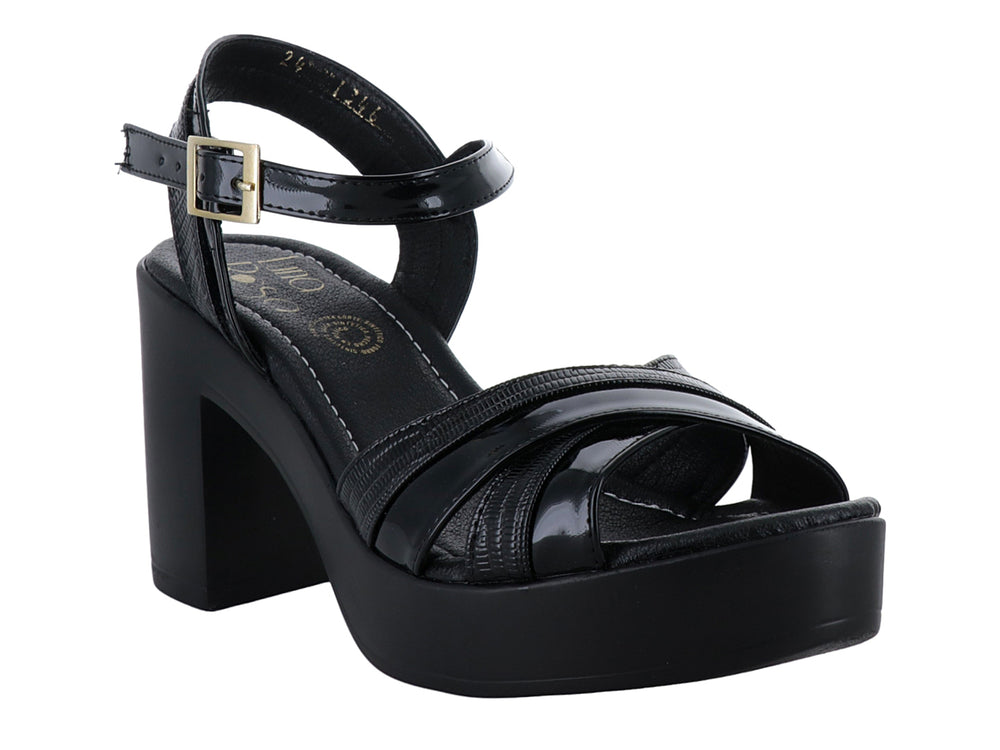 Sandalia de plataforma color negro con tacón grueso y correa ajustable al tobillo con hebilla dorada.