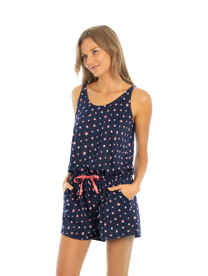 Mujer vistiendo pijama jumper color azul marino con estampado de estrellas rosas y cordón en la cintura.