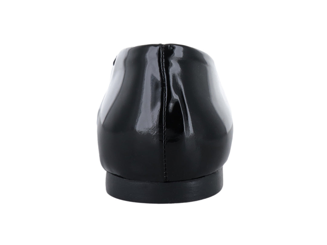 Zapato plano negro brillante con detalle de moño decorativo en la punta.