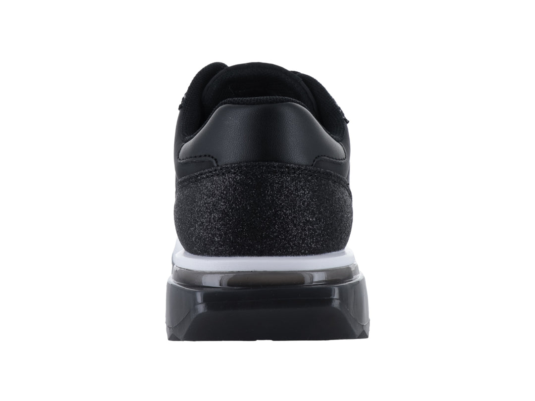 Tenis negros Guess con acabado brillante y suela blanca.