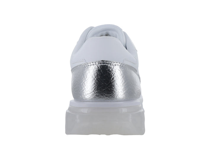 Tenis Guess color plata y blanco con acabado metálico y suela gruesa.