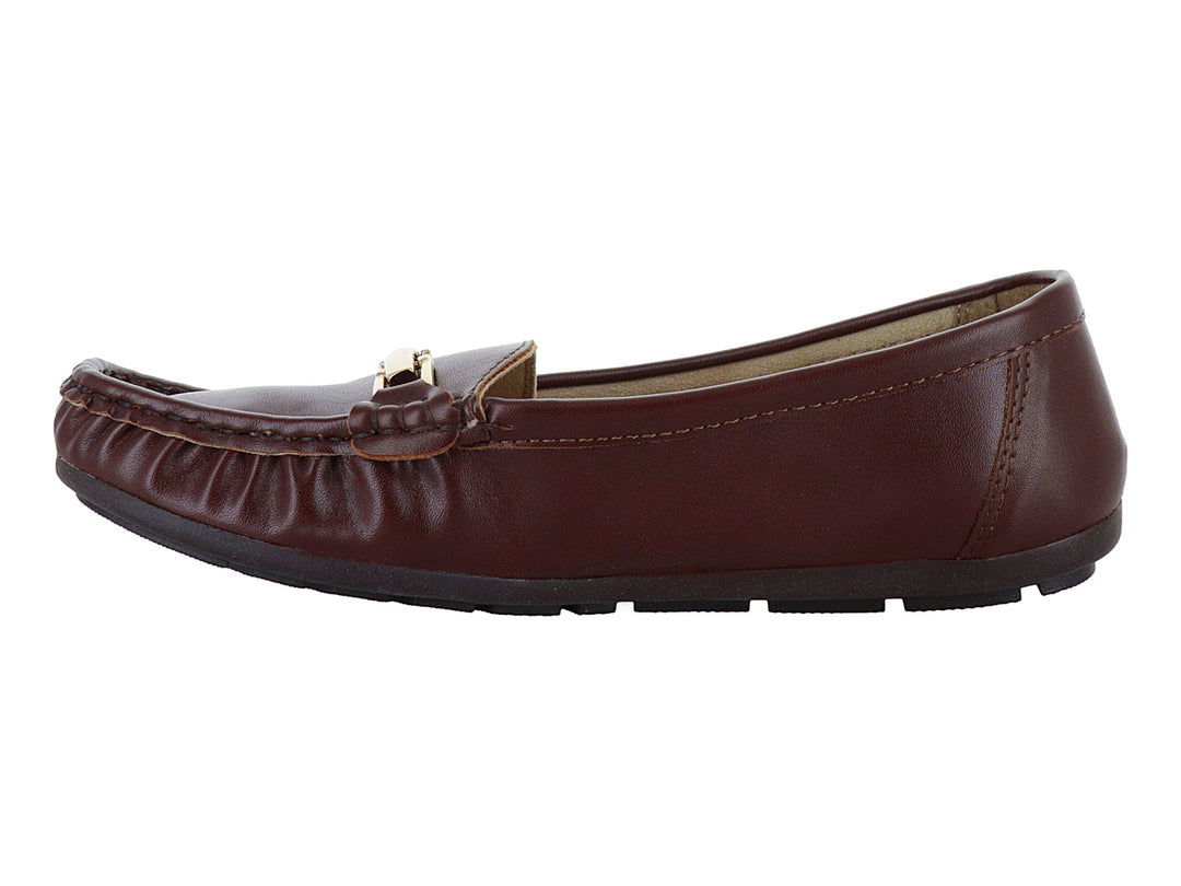 Zapato tipo mocasín color marrón madera con detalle de hebilla dorada y suela negra.