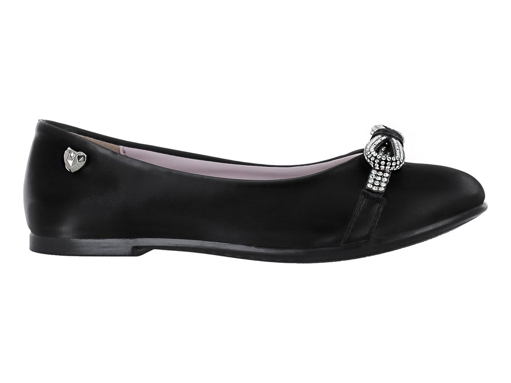 Zapato plano color negro con un moño decorado con brillantes en la parte frontal.