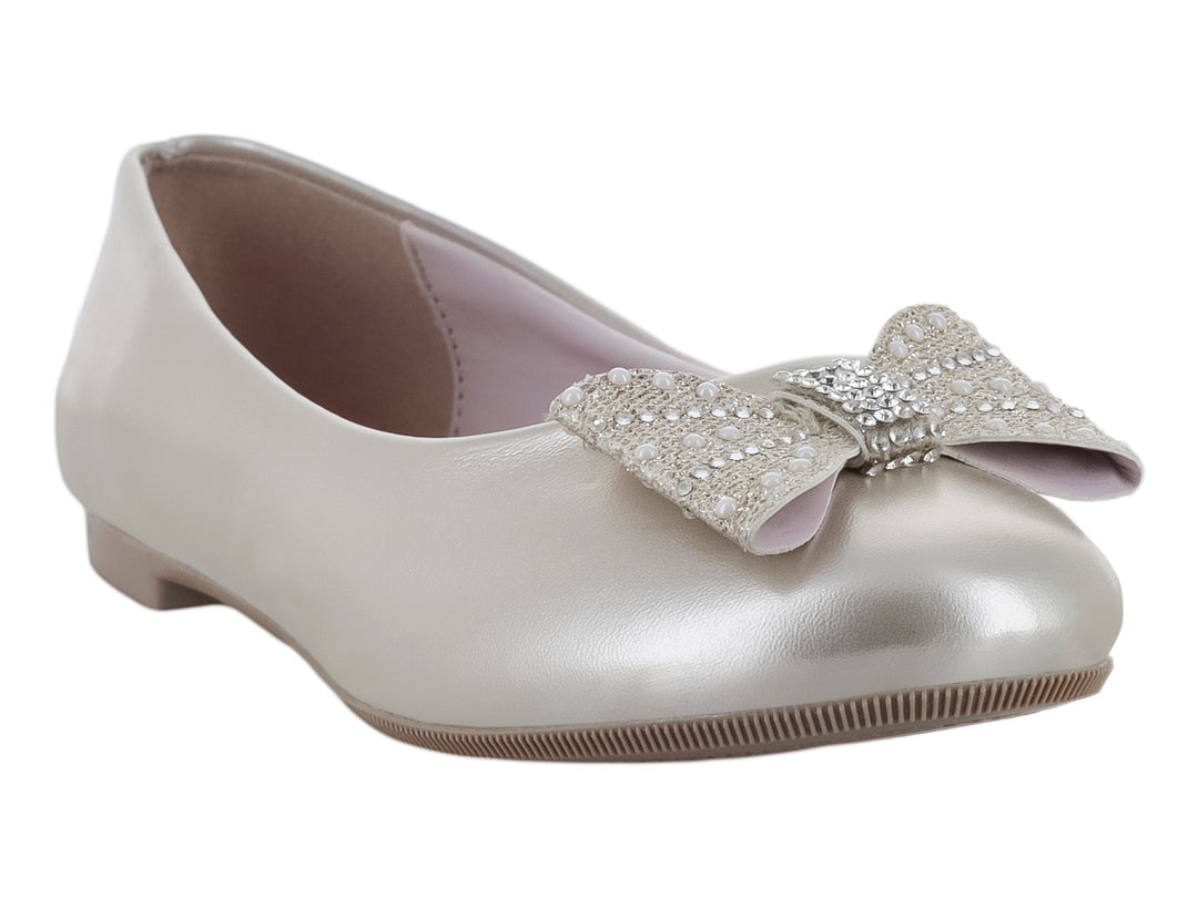 Zapato plano para niña en color plata metalizado con un moño decorado con pedrería brillante en la parte frontal.