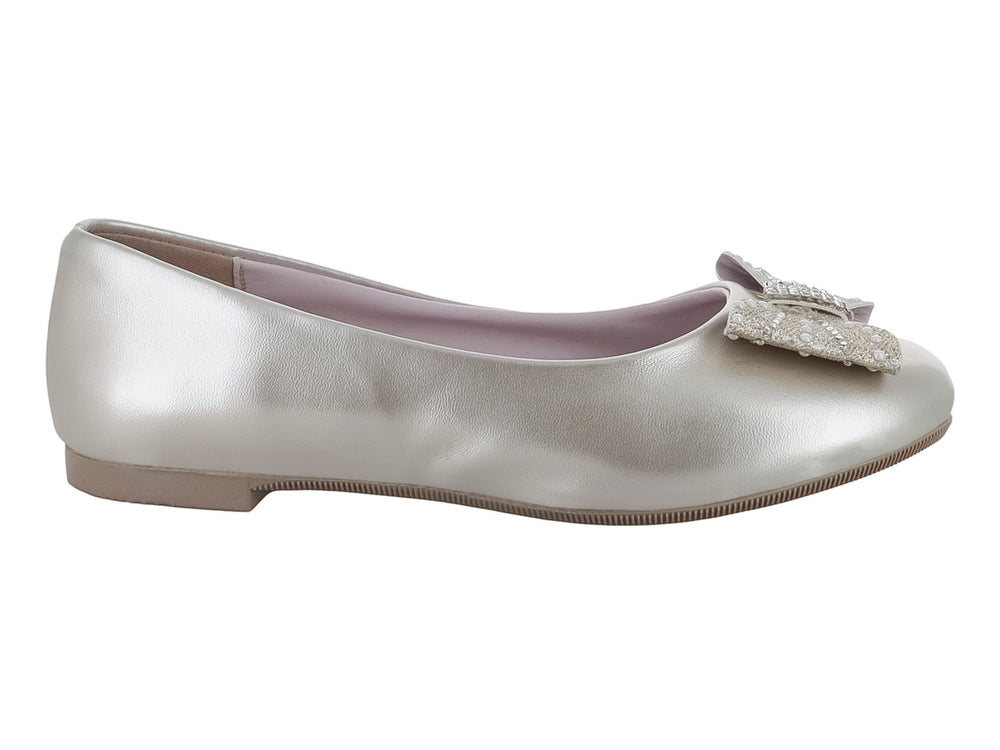Zapato plano para niña en color plata metalizado con un moño decorado con pedrería brillante en la parte frontal.