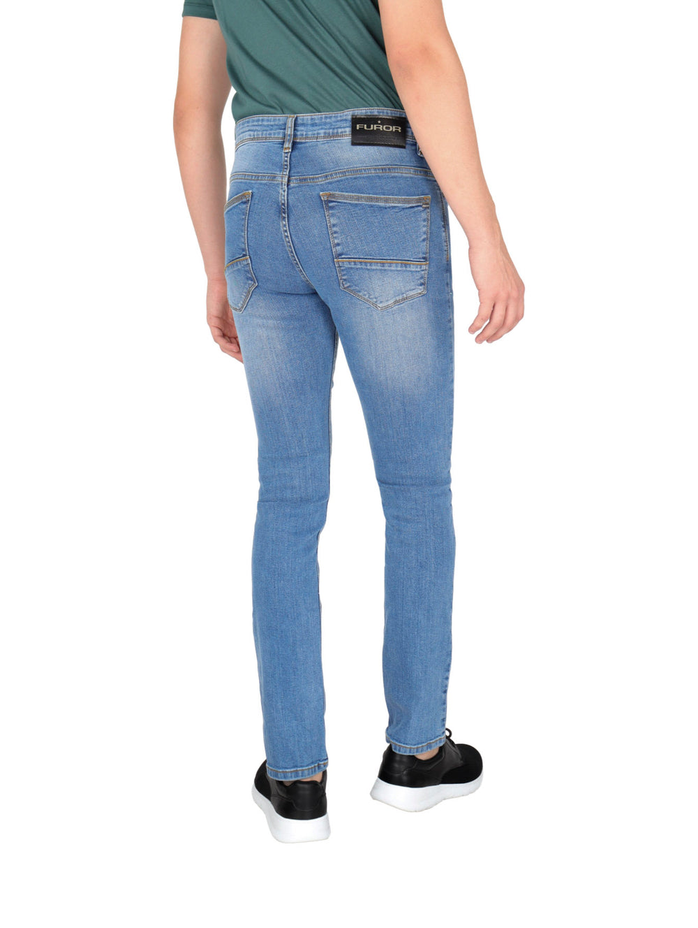 Hombre vistiendo pantalones jeans de color azul claro, camiseta verde y tenis negros.