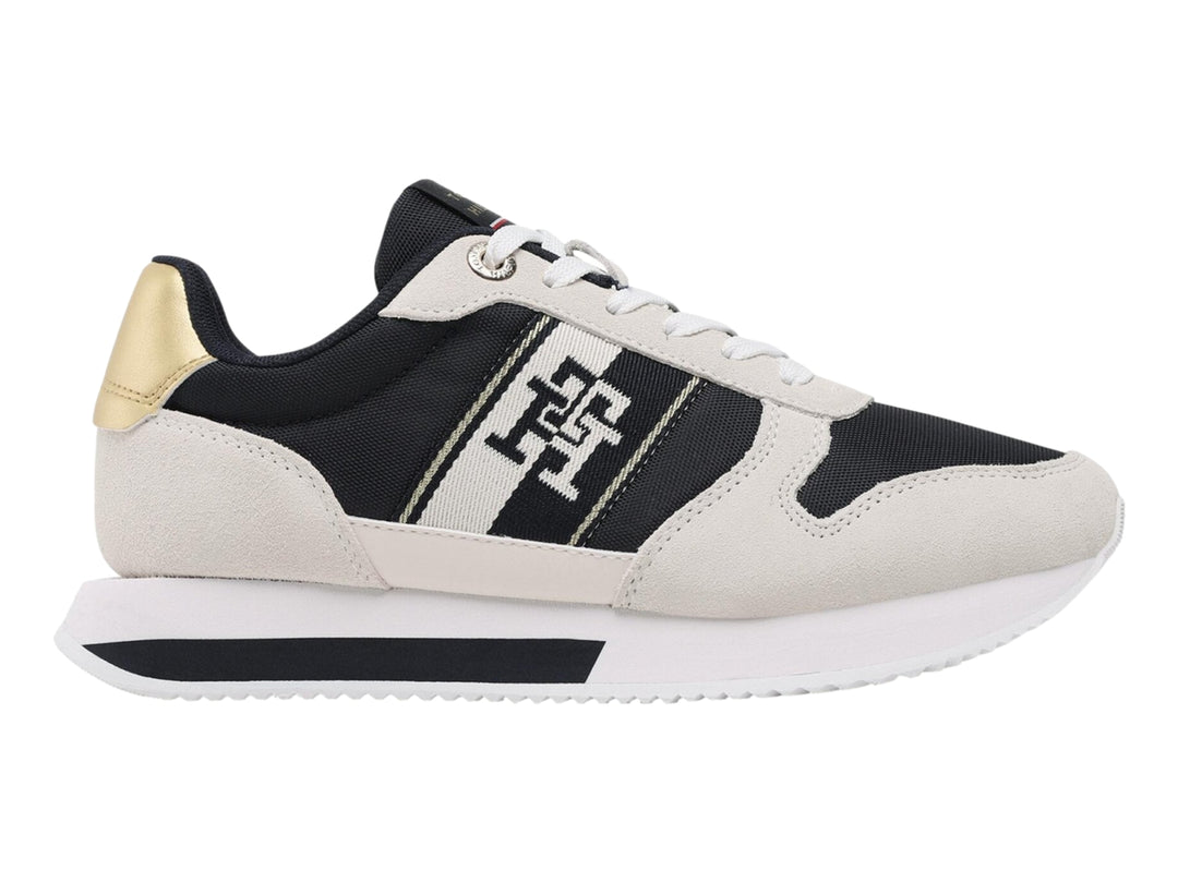 Tenis Tommy Hilfiger Runner en color blanco y azul marino con detalle dorado en el talón.