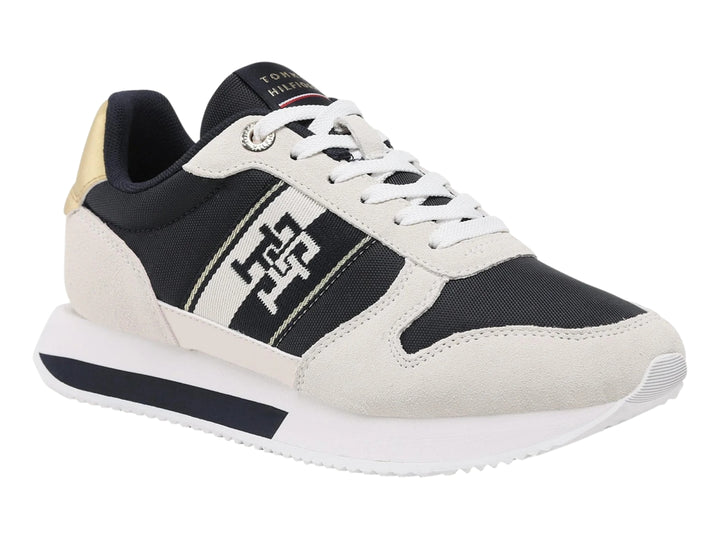 Tenis Tommy Hilfiger Runner en color blanco y azul marino con detalle dorado en el talón.