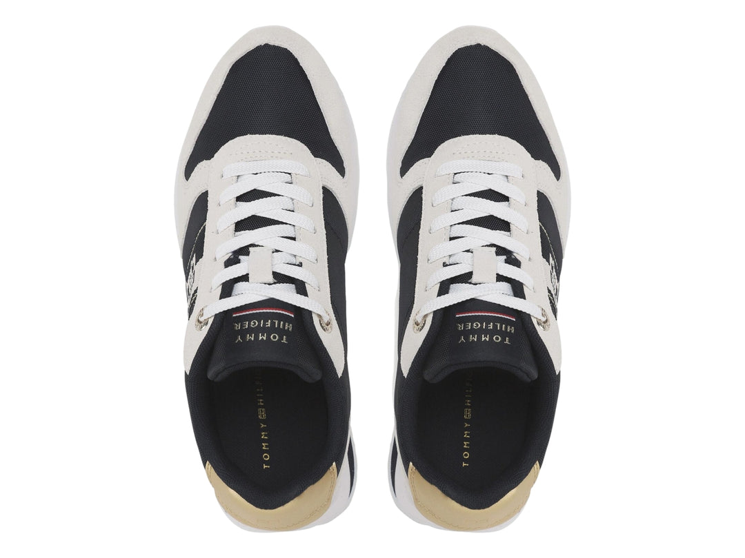 Tenis Tommy Hilfiger Runner en color blanco y azul marino con detalle dorado en el talón.
