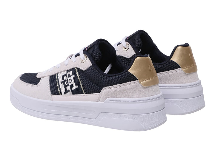 Tenis Tommy Hilfiger color azul marino y beige con suela blanca y detalles dorados en el talón.