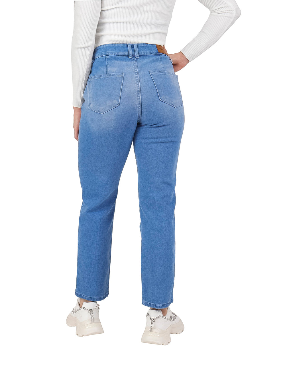 Mujer vistiendo pantalones jeans de mezclilla color azul claro con corte recto y tenis blancos.