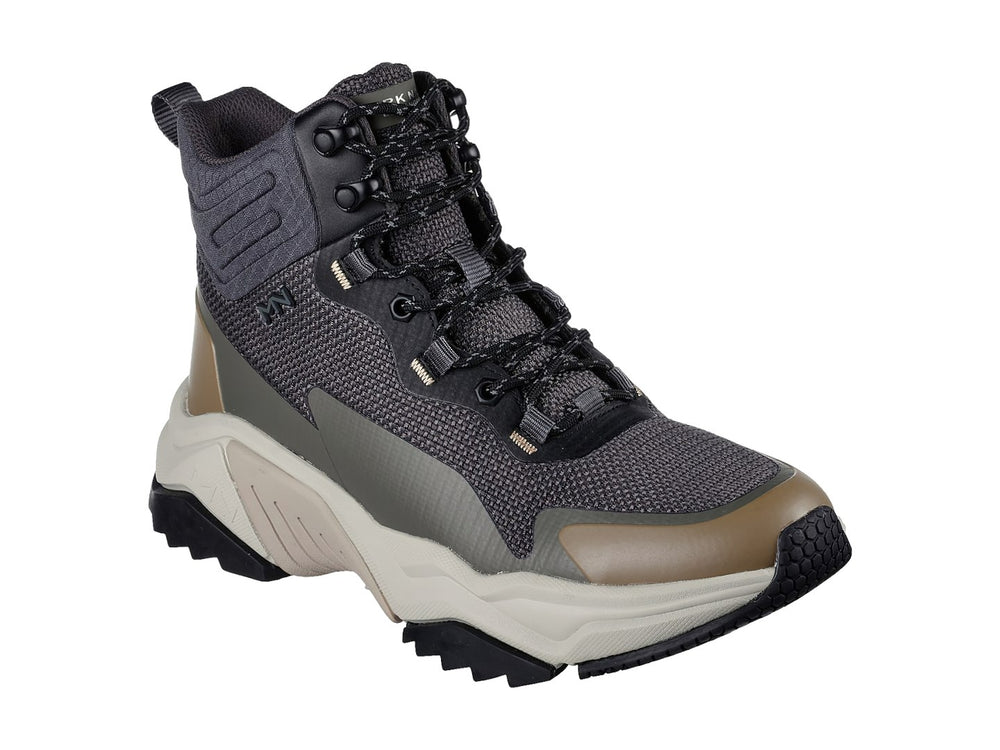 Botín deportivo Skechers color negro y oliva con suela gruesa en tono beige.