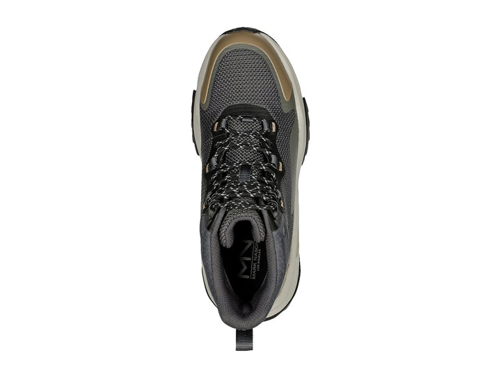 Botín deportivo Skechers color negro y oliva con suela gruesa en tono beige.