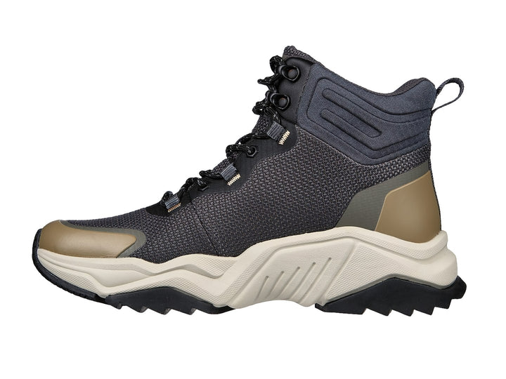 Botín deportivo Skechers color negro y oliva con suela gruesa en tono beige.