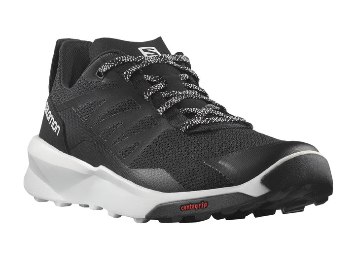 Tenis deportivos Salomon de color negro con suela blanca y detalles en rojo.