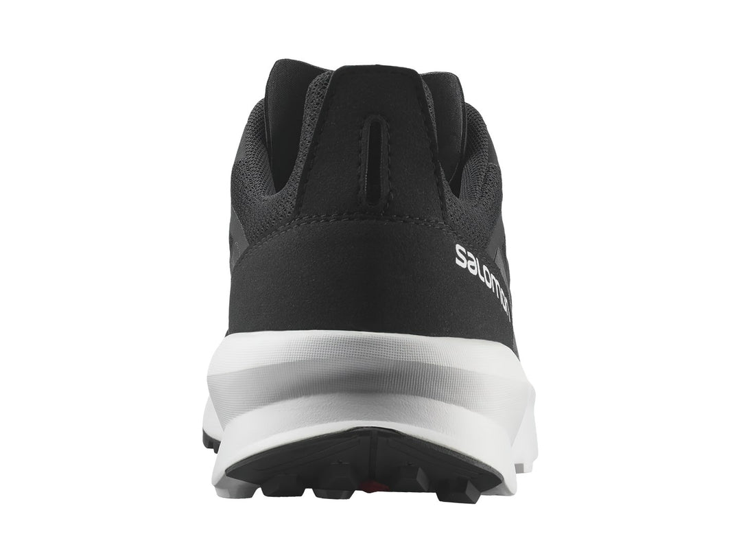Tenis deportivos Salomon de color negro con suela blanca y detalles en rojo.