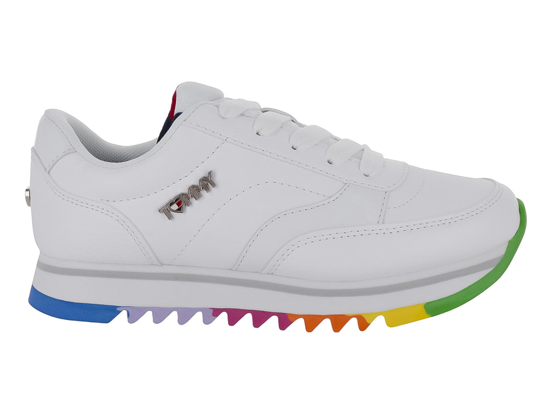 Tenis blancos Tommy Hilfiger con suela multicolor arcoíris y agujetas blancas.