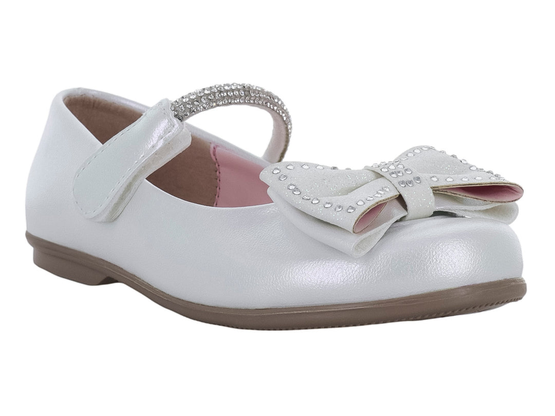 Zapato plano blanco para niña con moño adornado con pedrería y correa superior.