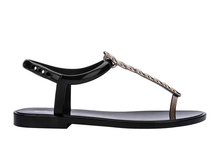 Sandalias negras Melissa con detalle de cadena de strass dorado y correa al tobillo.
