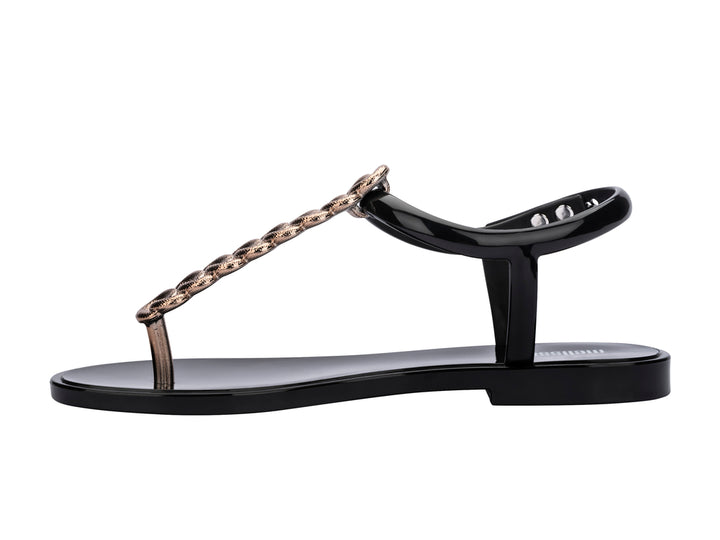 Sandalias negras Melissa con detalle de cadena de strass dorado y correa al tobillo.