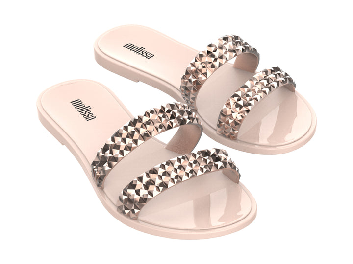 Par de sandalias Melissa color rosa con dos tiras decoradas con tachuelas plateadas brillantes.