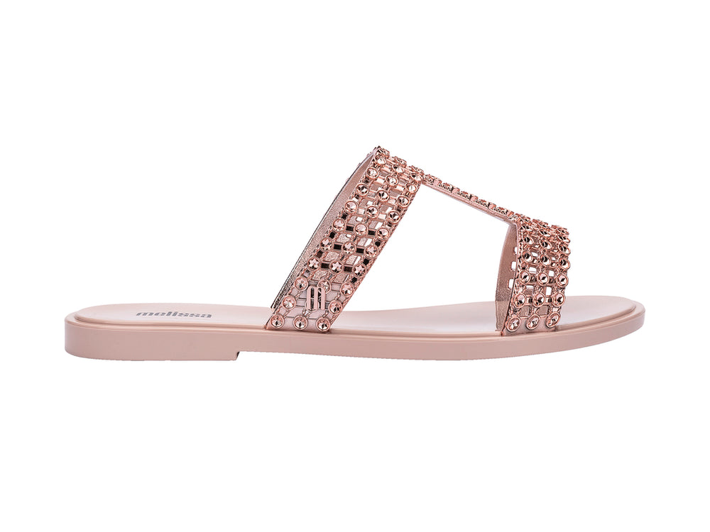 Sandalias Melissa Glowing Slide en color rosa con tiras decoradas con brillantes y suela plana.