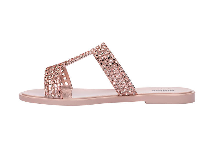Sandalias Melissa Glowing Slide en color rosa con tiras decoradas con brillantes y suela plana.