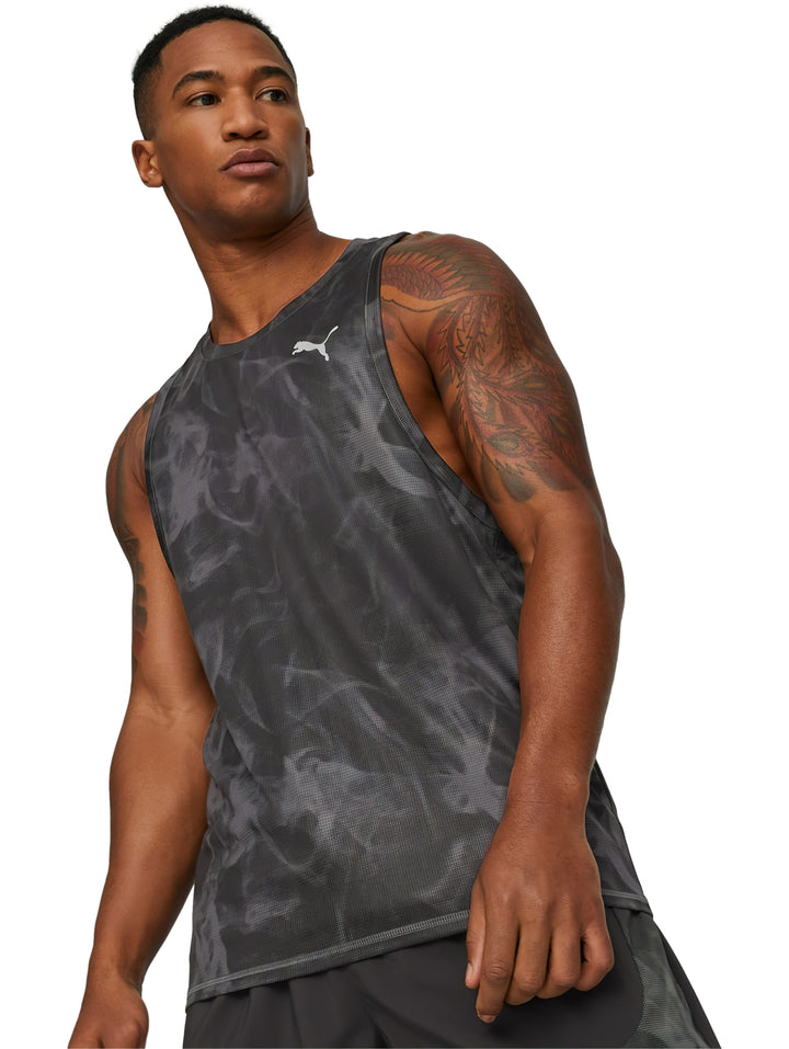 Hombre usando camiseta sin mangas PUMA negra con estampado abstracto y shorts deportivos.
