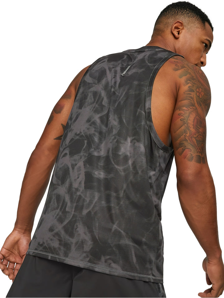 Hombre usando camiseta sin mangas PUMA negra con estampado abstracto y shorts deportivos.