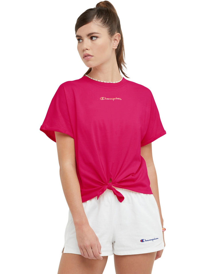 Camiseta rosa Champion para mujer con detalle de nudo en la parte frontal y cuello redondo.