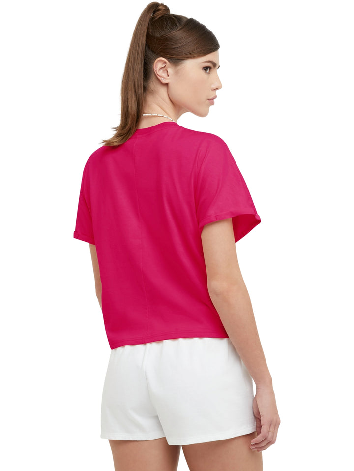 Camiseta rosa Champion para mujer con detalle de nudo en la parte frontal y cuello redondo.