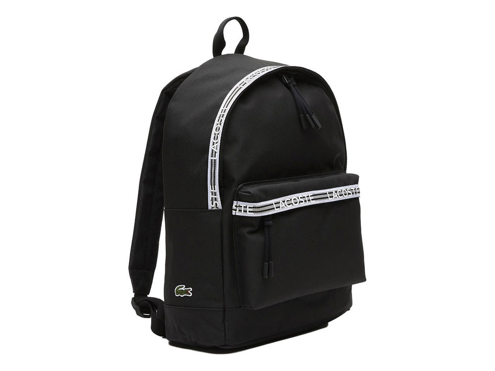 Mochila Lacoste color negro con una banda horizontal blanca decorativa en el bolsillo frontal.