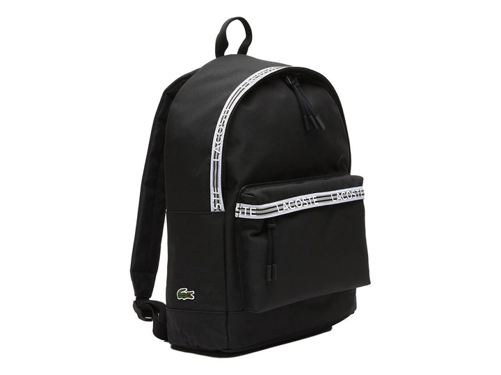 Mochila Lacoste color negro con una banda horizontal blanca decorativa en el bolsillo frontal.