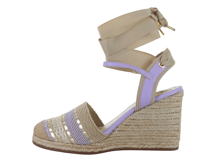 Sandalia de cuña en colores lila y beige con detalles dorados y cinta para amarrar al tobillo.