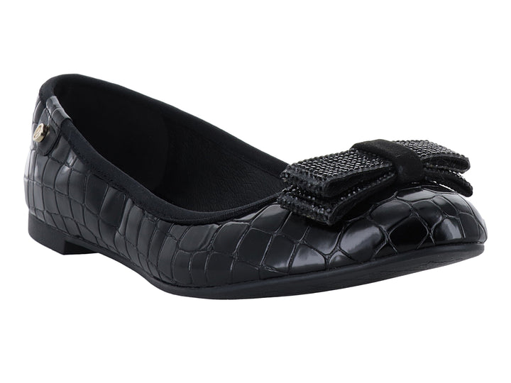 Zapato plano negro con textura de cocodrilo y moño decorativo frontal.