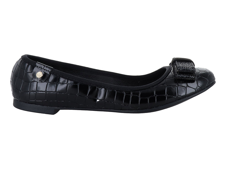Zapato plano negro con textura de cocodrilo y moño decorativo frontal.