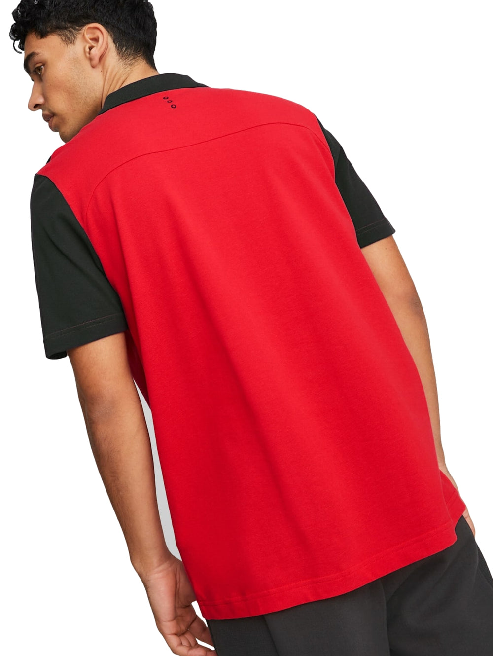 Hombre vistiendo polo deportivo PUMA color rojo con detalles en negro y logos de Ferrari y PUMA.