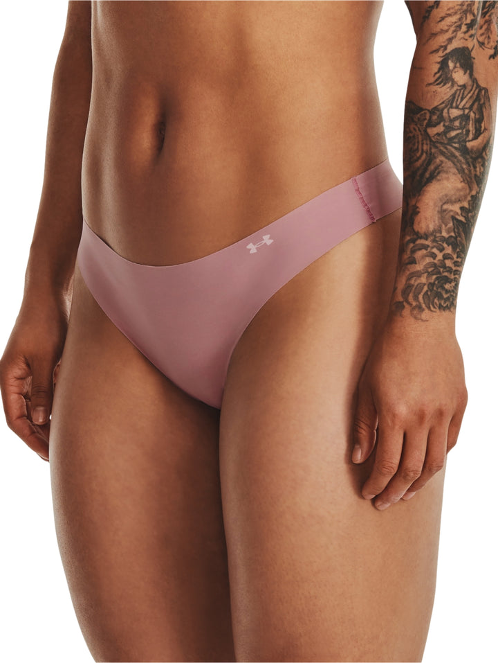 Mujer vistiendo una tanga deportiva de color rosa de la marca Under Armour.