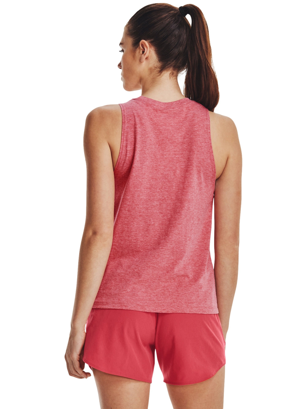 Mujer vistiendo una camiseta sin mangas rosa de Under Armour con logotipo blanco frontal y shorts a juego.