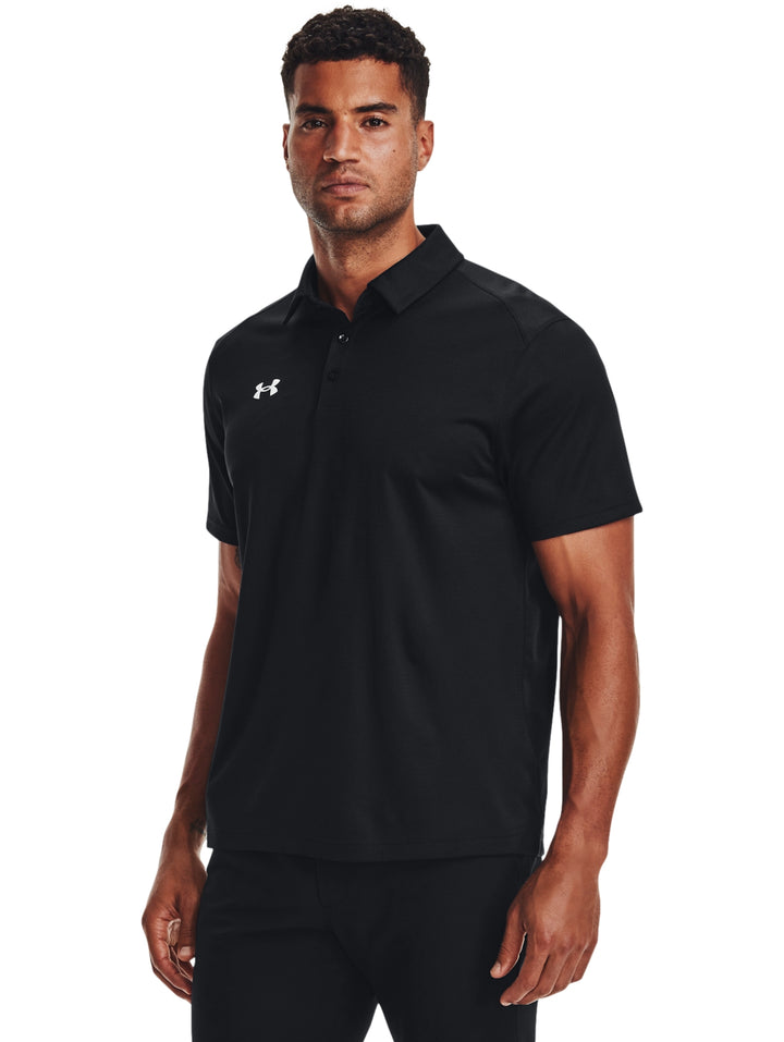 Hombre vistiendo una playera polo Under Armour de color negro, estilo deportivo y manga corta.