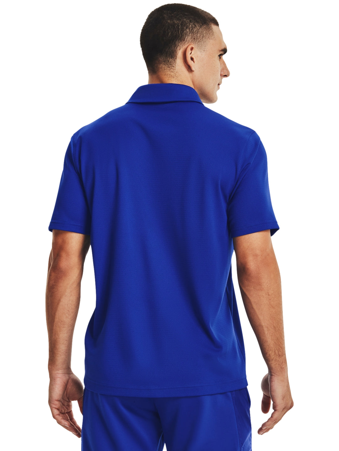 Hombre vistiendo polo deportivo azul de Under Armour con cuello y manga corta.