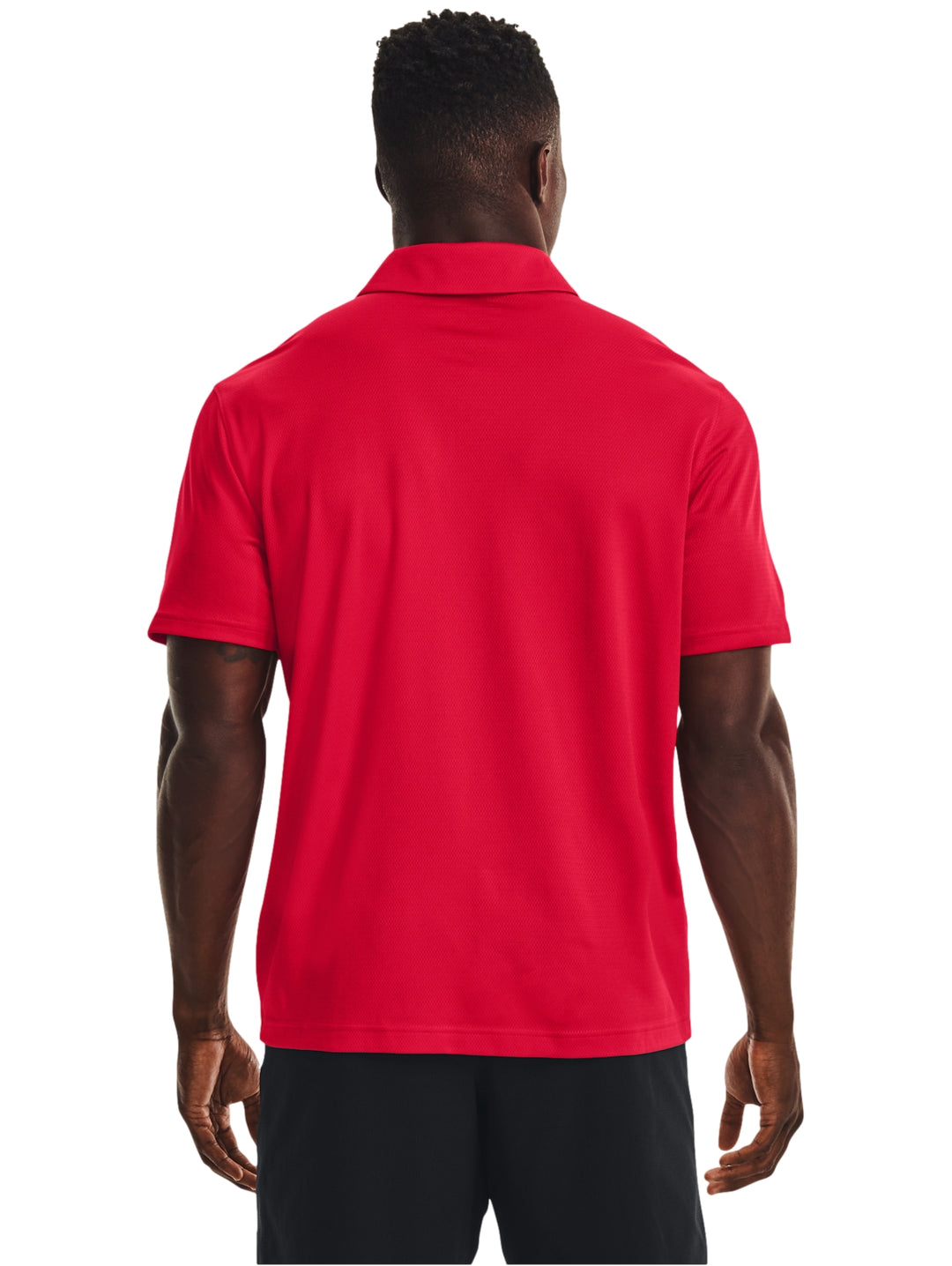 Hombre vistiendo una playera polo Under Armour de color rojo, estilo deportivo y ajuste atlético.