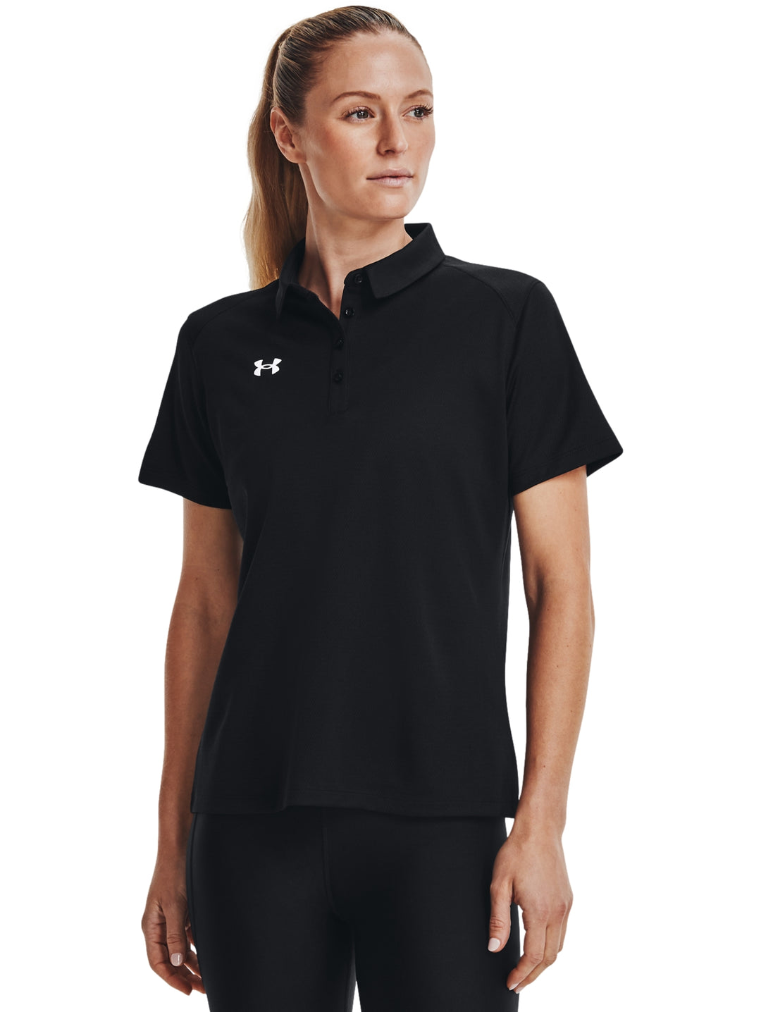 Mujer vistiendo polo deportivo Under Armour de color negro con cuello y manga corta.