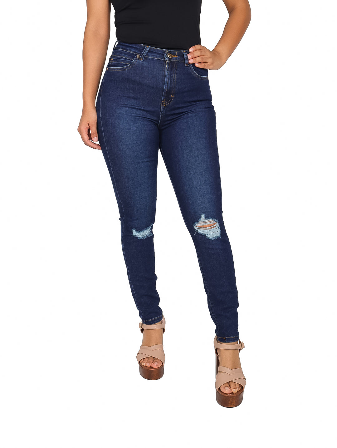 Mujer vistiendo pantalón jeans ajustado color azul oscuro con detalles de destrucción en las rodillas.