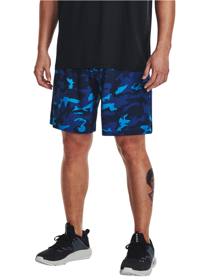 Hombre vistiendo shorts deportivos con estampado de camuflaje en tonos azules.